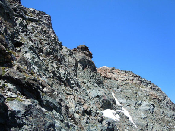 Pizzi dei Piani - In discesa, nel traverso sopra la fascia di rocce rossastre. Al centro, la torre di vetta
